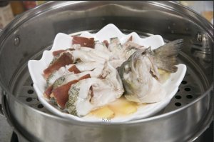 將鱸魚成花狀擺好，將火腿切片放入各縫隙中，放入鍋中隔水蒸12分鐘拿出，撒上蔥花即可。