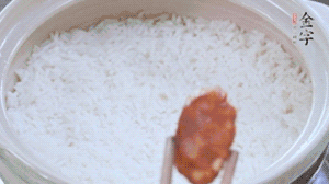 煮開后轉小火，當米飯出現(xiàn)小孔時，鋪上金字麻辣香腸。