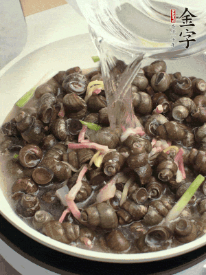 倒處理干凈的螺螄翻炒，加3勺料酒。加清水蓋過螺螄，中火蓋蓋煮5分鐘。