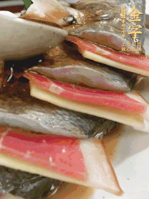 魚肚中塞蔥結、火腿片，魚身上碼放姜片、火腿片，倒入混合的料汁。